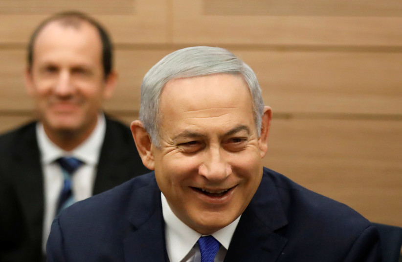 Israeli Prime Minister Benjamin Netanyahu smiles as he attends the Foreign Affairs and Defense Committee at the Knesset, Israel's Parliament, in Jerusalem November 19, 2018 (photo credit: AMIR COHEN/REUTERS)