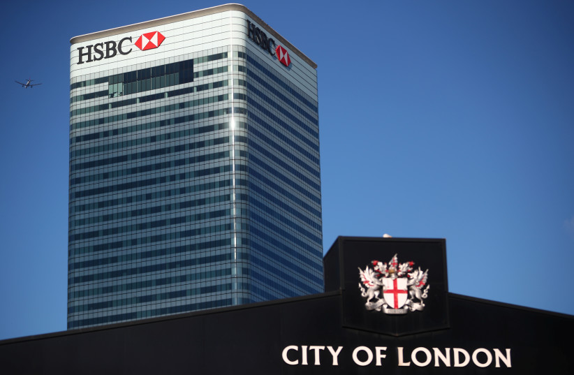 Barclays' building in Canary Wharf is seen behind a City of London sign outside Billingsgate Market in London. (photo credit: REUTERS)