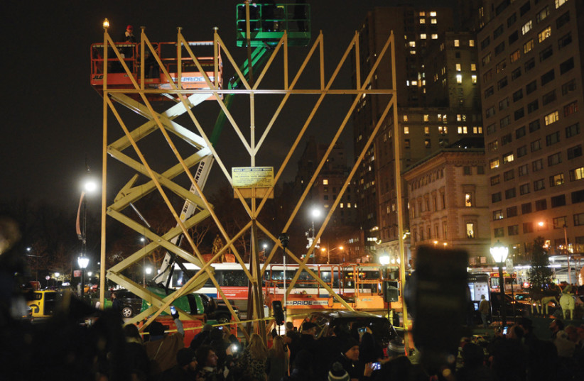 A RABBI lights the ‘World’s Largest Menorah’ in Manhattan in 2017. (photo credit: ANDREW SAVULICH/TNS)