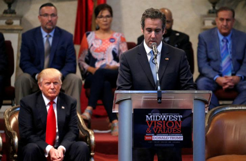 President Donald Trump listens as his former personal attorney Michael Cohen delivers remarks on his behalf (photo credit: REUTERS/JONATHAN ERNST)