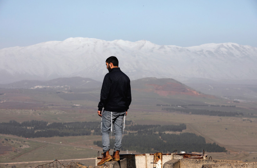 A MAN stands at Mount Bental, an observation post on the Golan Heights that overlooks the Syrian side of the Quneitra crossing, on January 21. (photo credit: REUTERS)