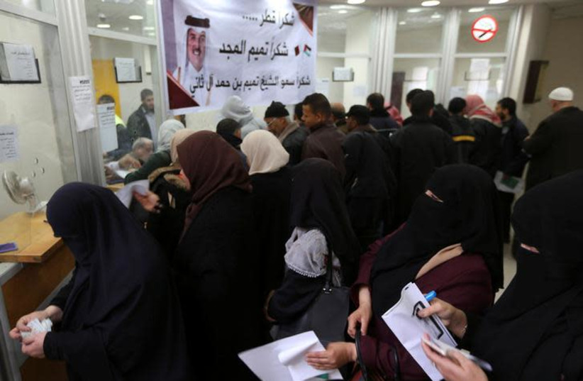 Palestinian Hamas-hired civil servants wait to receive their salaries paid by Qatar (photo credit: REUTERS/IBRAHEEM ABU MUSTAFA)