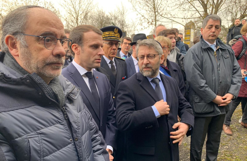  President of France Emmanuel Macron (center) visits the desecrated Quatzenheim cemetery in eastern France on Tuesday (photo credit: YONAH JEREMY BOB)