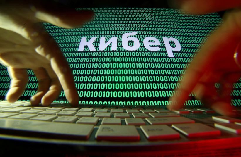 Hands are seen on a keyboard in front of a displayed cyber code in this picture illustration taken October 4, 2018 (photo credit: DADO RUVIC/REUTERS)