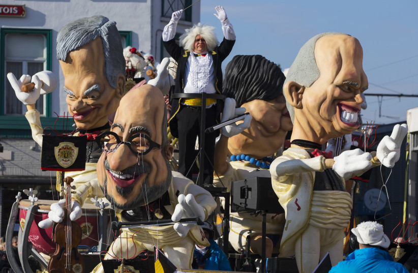 Giant figures depicting Belgian Prime Minister Charles Michel (C) and other politicians are seen during the 87th carnival parade of Aalst February 15, 2015. The Aalst Carnival, which is inscribed on the Representative List of the Intangible Cultural Heritage of Humanity, often shows informal groups  (photo credit: YVES HERMAN / REUTERS)
