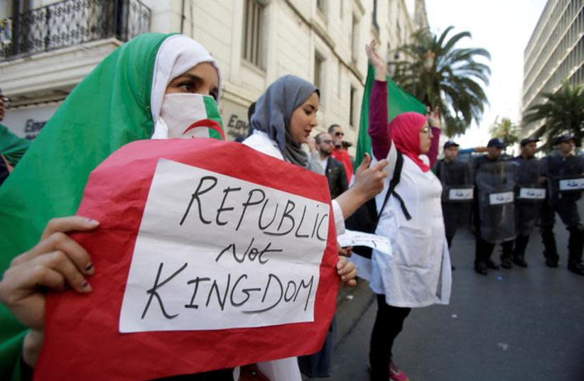 A demonstrator carries a sign as teachers and students take part in a protest demanding immediate political change in Algiers, Algeria March 13, 2019 (photo credit: REUTERS/RAMZI BOUDINA)
