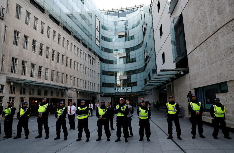 Police officers protect the entrance to the BBC building (photo credit: STEFAN WERMUTH/REUTERS)