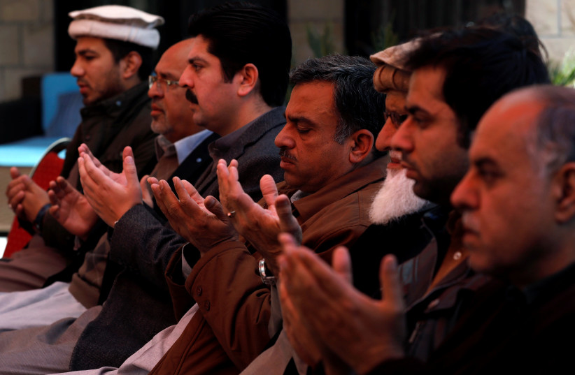 Relatives and family members of Naeem Rashid who was killed along with his son Talha Naeem in the Christchurch mosque attack in New Zealand, pray during a condolence gathering at the family's home in Abbottabad, Pakistan March 17, 2019 (photo credit: REUTERS)