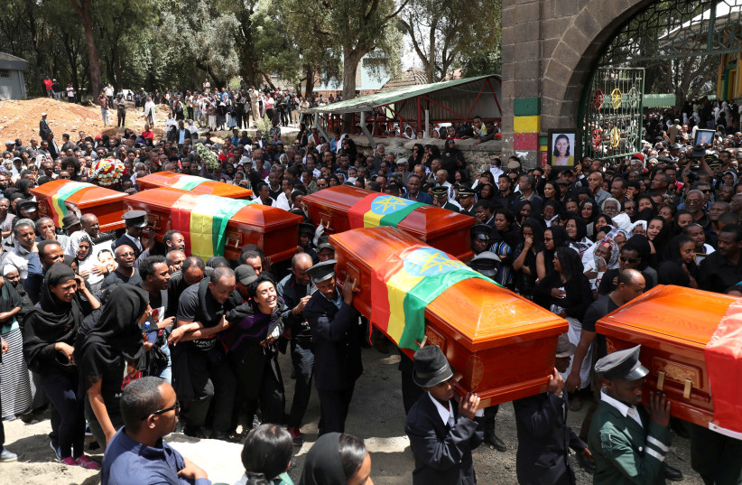 Pallbearers carry the coffins of the victims of the Ethiopian Airline Flight ET 302 plane crash, during the burial ceremony at the Holy Trinity Cathedral Orthodox church in Addis Ababa, Ethiopia, March 17, 2019.  (photo credit: REUTERS/TIKSA NEGERI)