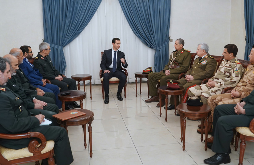 President Bashar al-Assad (C) meeting with Iraq's Chief of Staff Othman al-Ghanimi (4th-R) and Iran's Chief of Staff Mohammad Hossein Bagheri (5th-L) in the presence of Syrian Defence Minister Ali Abdullah Ayyoub (3rd-R) in the Syrian capital Damascus  (photo credit: SANA/AFP)
