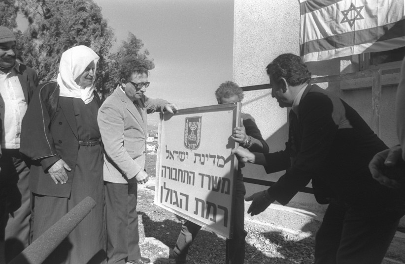 Transportation Minister Haim Corfu placing a sign  on the Golan Heights after its annexation as a Druze Israeli looks on, December 23, 1981 (photo credit: GPO ARCHIVES)
