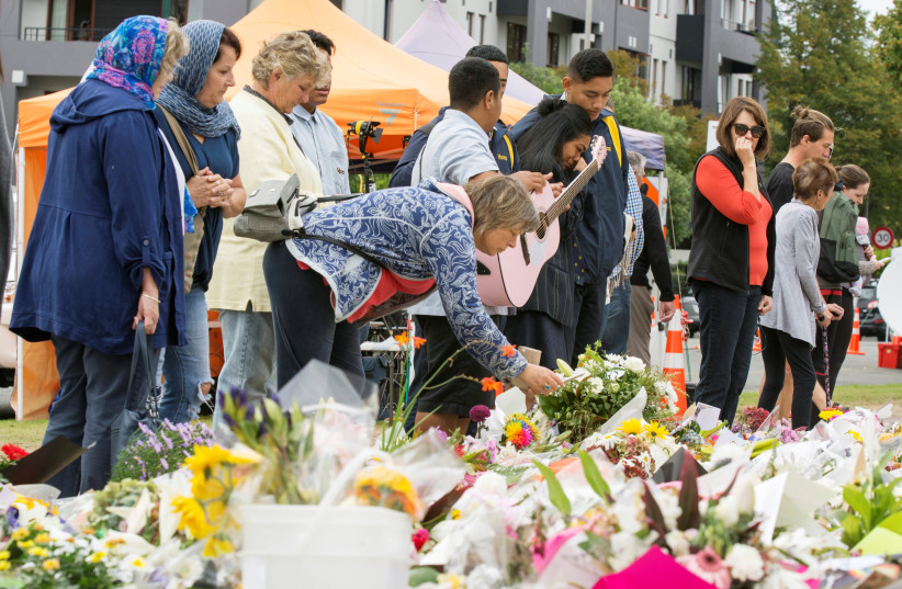 People place flowers near the police cordon for the Linwood Islamic Centre (photo credit: STRINGER/ REUTERS)