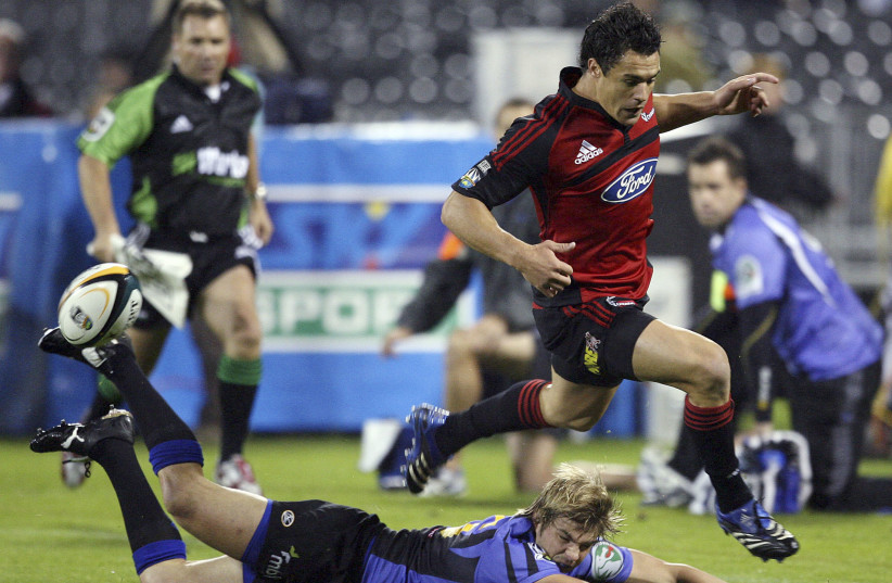 Christchurch Crusaders player Daniel Carter (R) leaps during a Rugby Super 14 match in Christchurch April 7, 2007 (photo credit: REUTERS/PETER MEECHAM)