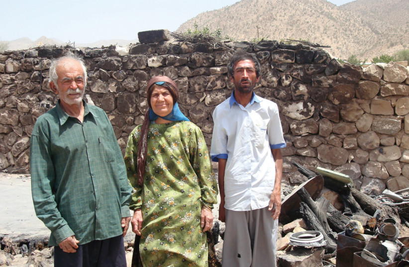 A BAHA’I family in Fars province stands near where an arson attack was committed. (photo credit: Courtesy)
