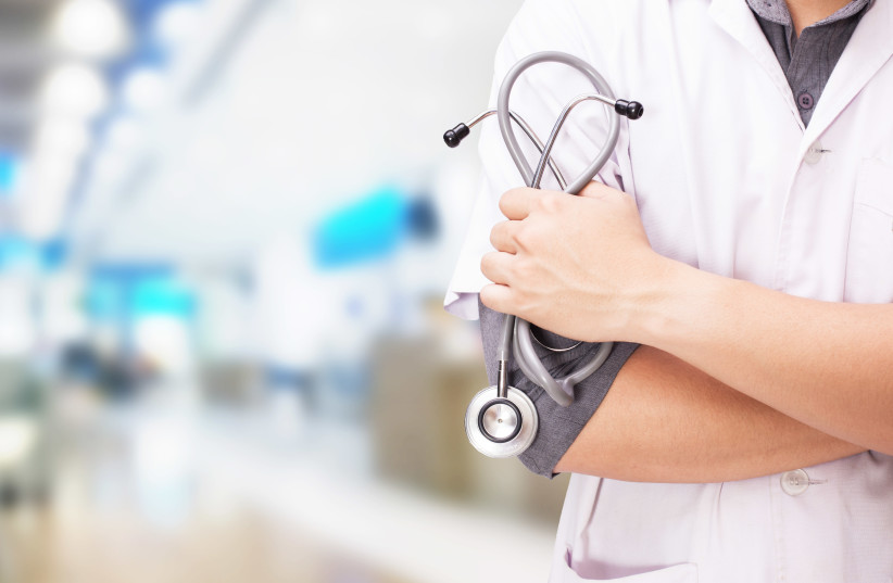 Doctor with a stethoscope in the hands and hospital background (illustrative) (photo credit: INGIMAGE)