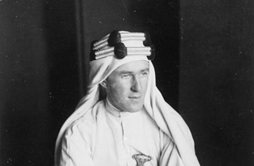 T E Lawrence 1888-1935 Lawrence in Arab dress seated on the ground (photo credit: Wikimedia Commons)