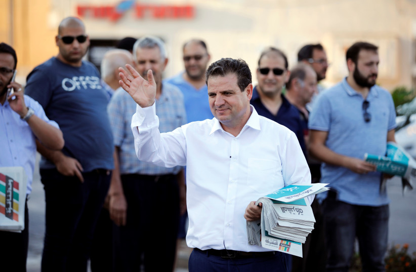 Ayman Odeh, leader of the Joint List, gestures as he hands out pamphlets during an election campaign event in Tira last week.  (photo credit: REUTERS/AMIR COHEN)