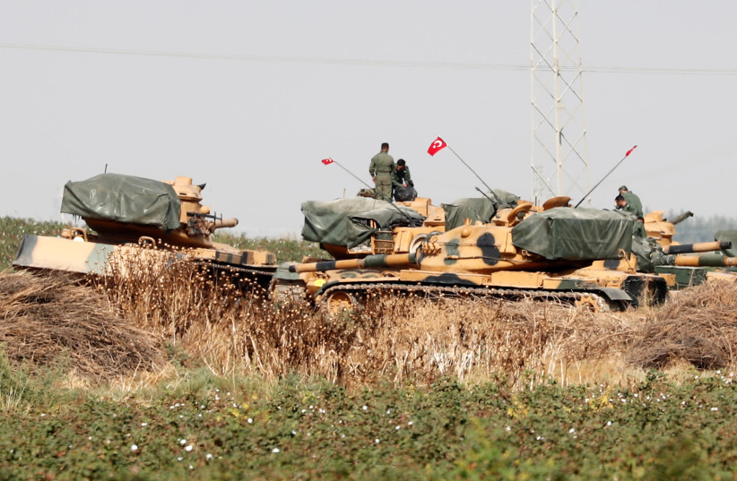 Turkish soldiers stand on top of tanks near the Turkish-Syrian border in Sanliurfa province, Turkey, October 15, 2019 (photo credit: REUTERS/MURAD SEZER)