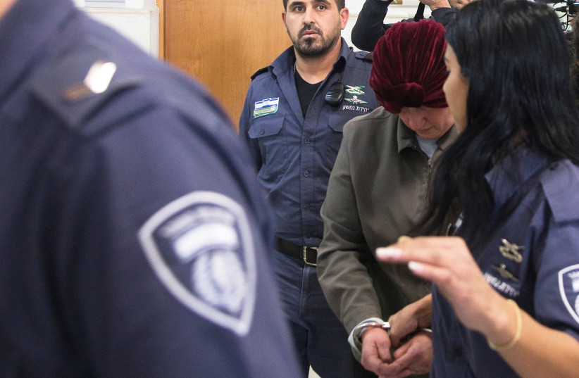 Malka Leifer, a former Australian school principal who is wanted in Australia on suspicion of sexually abusing students, walks in the corridor of the Jerusalem District Court accompanied by Israeli Prison Service guards, in Jerusalem (photo credit: REUTERS/Ronen Zvulun)