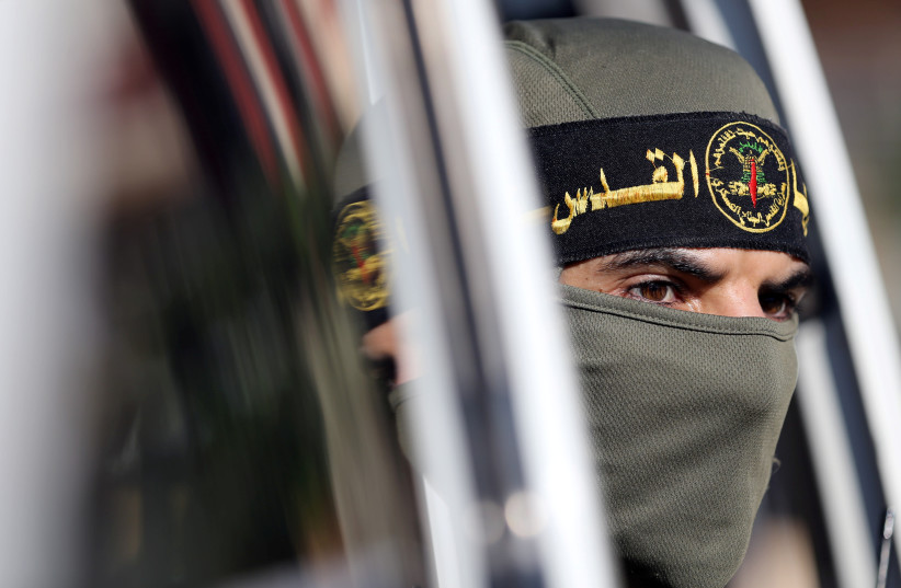 A Palestinian Islamic Jihad militant looks out of a vehicle during a military show marking the 32nd anniversary of the organisation's founding, in the central Gaza Strip October 3, 2019 (photo credit: REUTERS/IBRAHEEM ABU MUSTAFA)