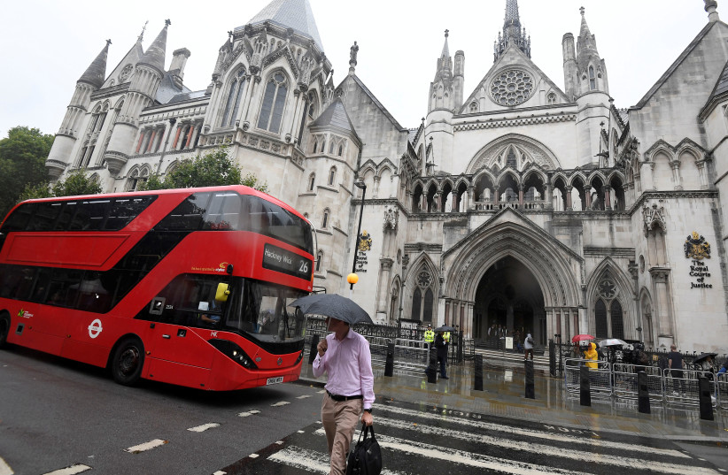 A London bus is driven past The Royal Courts of Justice in London, Britain, July 30, 2019 (photo credit: REUTERS/TOBY MELVILLE)