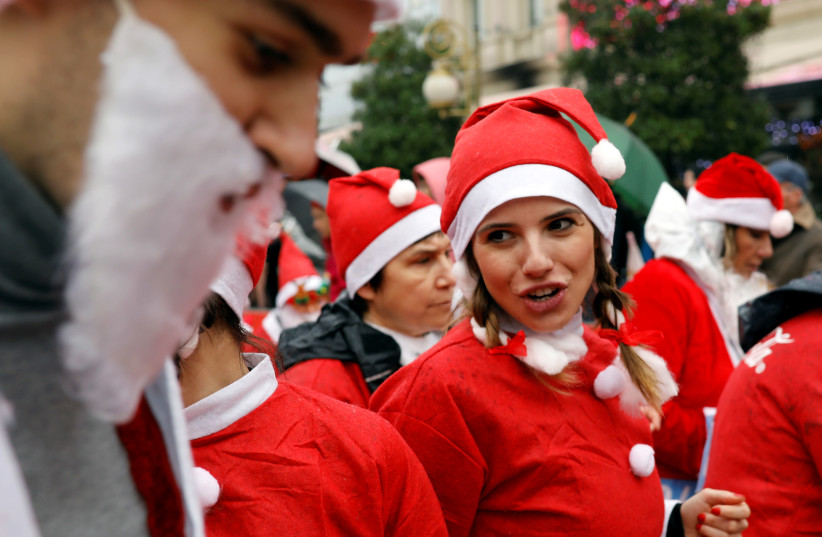 People wearing Santa Claus' uniforms run during the annual city race in Skopje (photo credit: REUTERS)