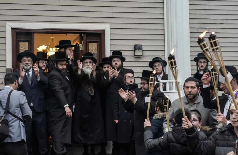 Rabbi Chaim Rottenberg celebrates with people the arrival of a new Torah at his residence in Monsey, New York, U.S., December 29, 2019 (photo credit: REUTERS/JEENAH MOON)