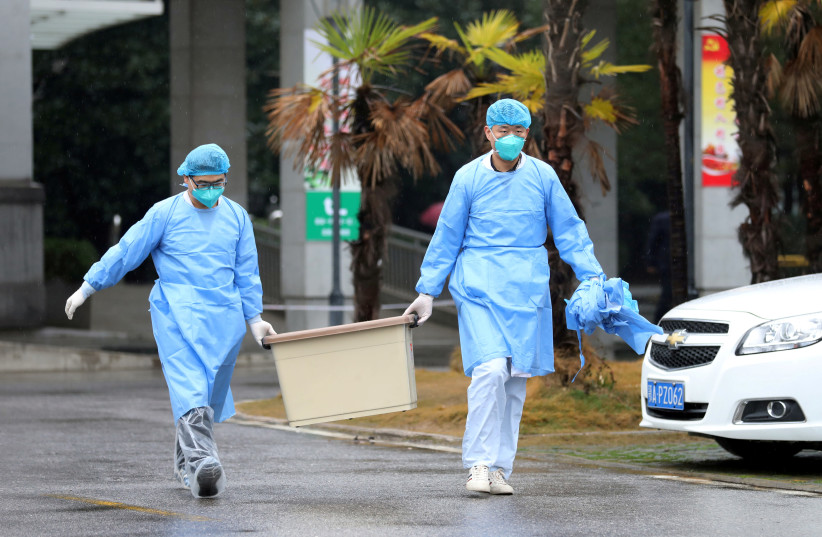 FILE PHOTO - Medical staff carry a box as they walk at the Jinyintan hospital, where the patients with pneumonia caused by the new strain of coronavirus are being treated, in Wuhan, Hubei province, China January 10, 2020. Picture taken January 10, 2020 (photo credit: REUTERS/STRINGER/FILES)