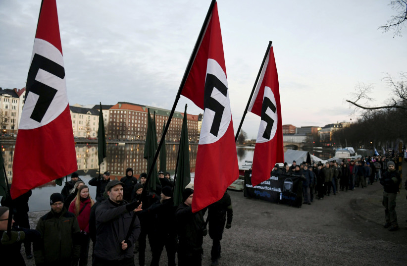 Finnish neo-nazis start their Independence Day march with swastika flags in Helsinki, Finland December 6, 2018. (photo credit: MARTTI KAINULAINEN/LEHTIKUVA/VIA REUTERS)