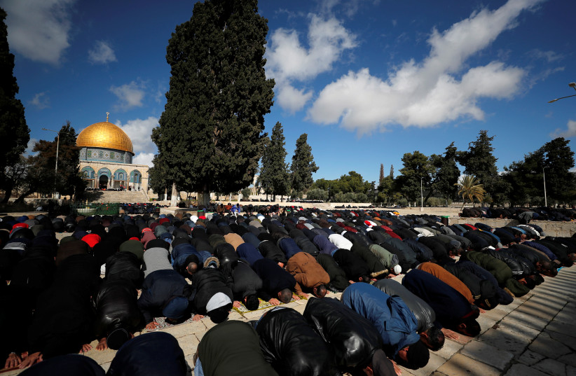 Palestinian men prays near the Dome of the Rock on the compound known to Muslims as the Noble Sanctuary and to Jews as Temple Mount in Jerusalem's Old City January 31, 2020 (photo credit: REUTERS/AMMAR AWAD)
