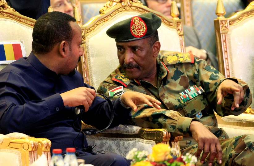 The head of Sudan's Transitional Military Council, Lieutenant General Abdel Fattah Al-Burhan, talks to Ethiopian Prime Minister Abiy Ahmed during the signing of a power sharing deal in Khartoum, Sudan, August 17, 2019 (photo credit: REUTERS/ MOHAMED NURELDIN ABDALLAH)