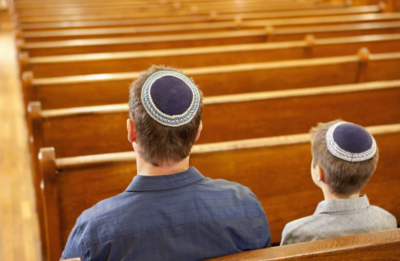 Father and son in a synagogue (photo credit: GABE FRIEDMAN (JTA))