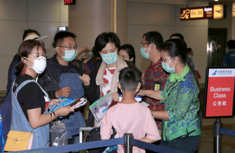 Airport staff check the tickets of passengers of a China Southern Airlines flight to Guangzhou, China, at I Gusti Ngurah Rai International Airport, Bali, Indonesia. (photo credit: ANTARA FOTO/FIKRI YUSUF/REUTERS)