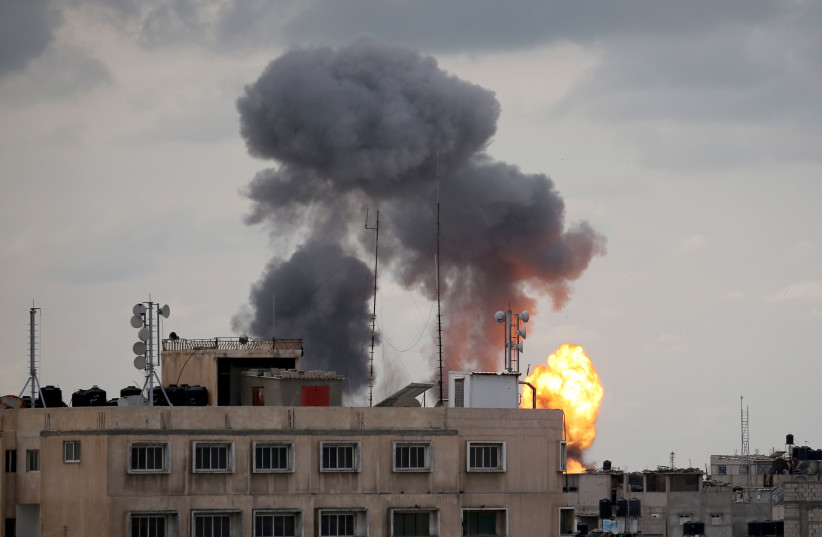 Flame and smoke are seen during an Israeli air strike in the southern Gaza Strip (photo credit: IBRAHEEM ABU MUSTAFA/REUTERS)