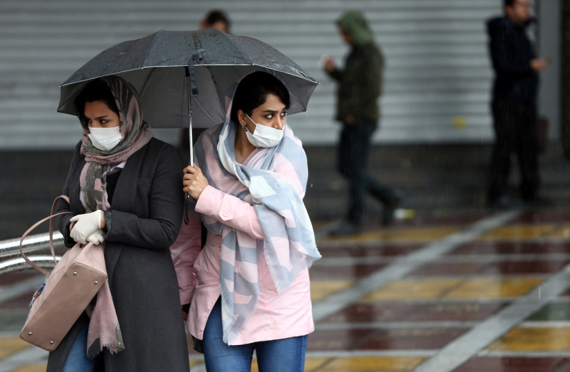 Iranian women wear protective masks to prevent contracting coronavirus, as they walk in the street in Tehran, Iran February 25, 2020. (photo credit: NAZANIN TABATABAEE/WANA VIA REUTERS)