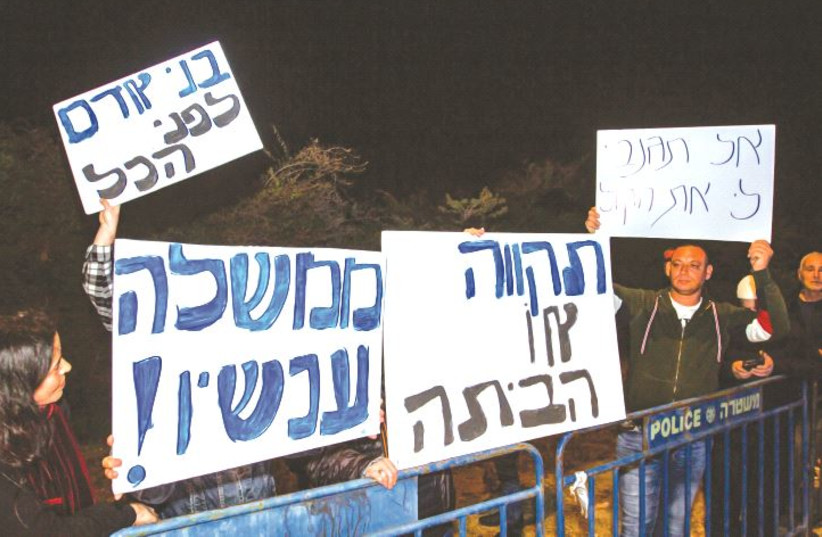 PROTESTERS STAND outside the Kibbutz Reshafim home of Gesher Party leader Orly Levy-Abecassis Wednesday night, following her decision not to support a Joint List-backed minority government.  (photo credit: FLASH90)