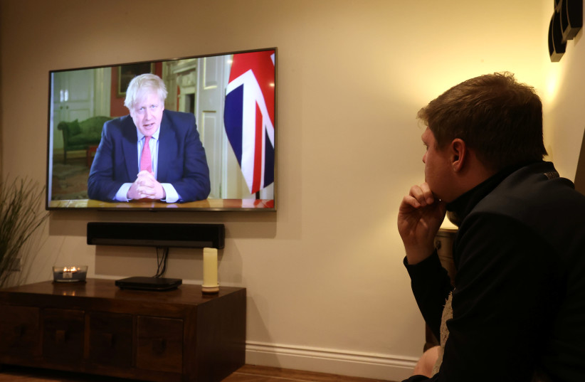 A man watches British Prime Minister Boris Johnson's press conference as the spread of coronavirus disease (COVID-19) continues in Newcastle-under-Lyme (photo credit: REUTERS/CARL RECINE)