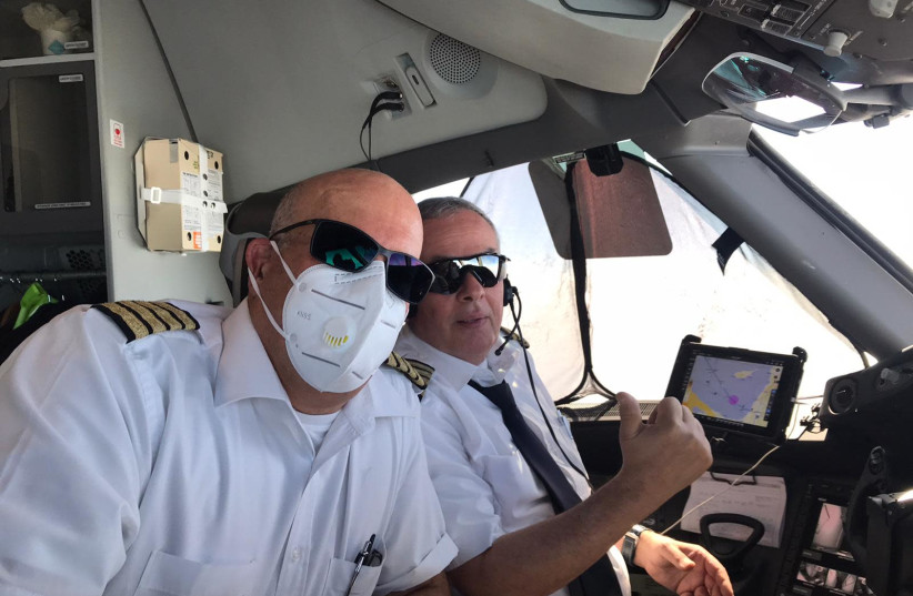 Pilots from the El Al flight returning with Israelis stranded in Colombia, wearing masks to prevent them from contracting the coronavirus. (photo credit: EL AL)