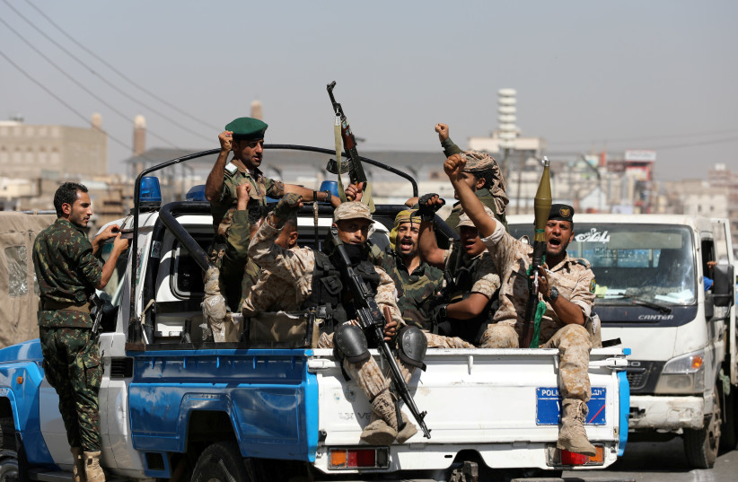 Houthi troops ride on the back of a police patrol truck after participating in a Houthi gathering in Sanaa, Yemen February 19, 2020 (photo credit: REUTERS/KHALED ABDULLAH)