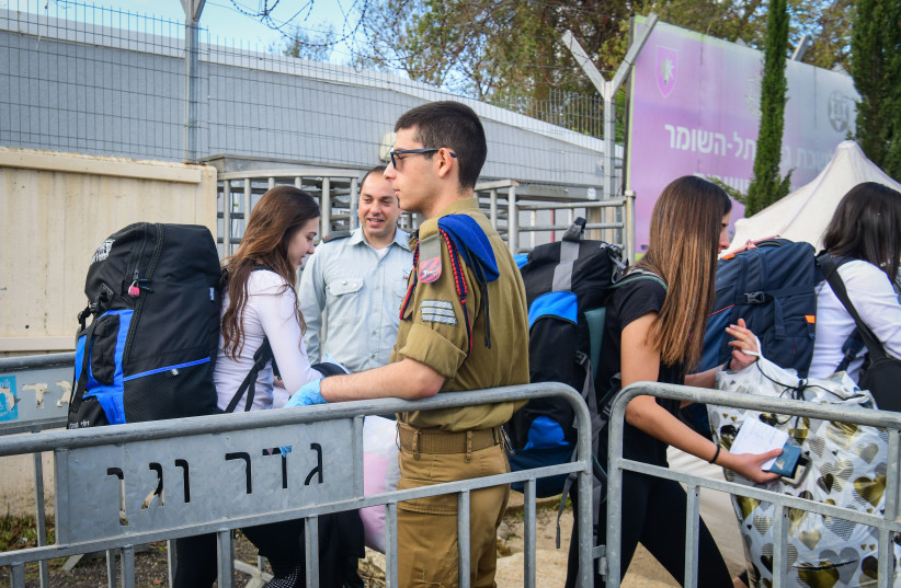 Young Israelis arrive to the Israeli army recruitment center at Tel Hashomer, outside of Tel Aviv on March 17, 2020. (photo credit: FLASH90)
