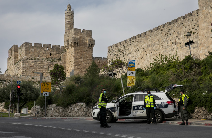 Police at a temporary "checkpoint"  outside the david tower in the Old City of Jerusalem on April 15, 2020, to check if people are not disobeying the governments orders on a lockdown, in order to prevent the spread of the Coronavirus. (photo credit: OLIVIER FITOUSSI/FLASH90)
