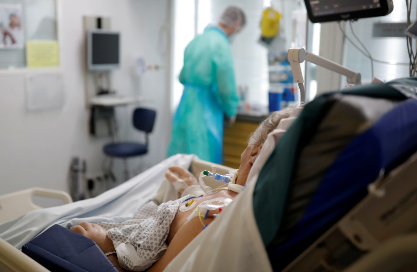 A patient suffering from the coronavirus disease (COVID-19) is treated an the Intensive Care Unit (ICU). May 6, 2020 (photo credit: STEPHANE MAHE / REUTERS)