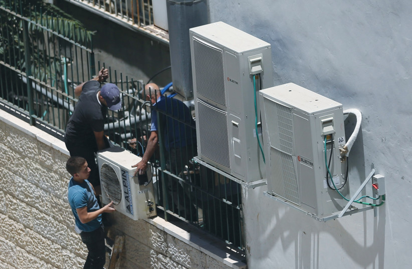 WORKERS INSTALL air conditioners on the wall of a building in the center of Jerusalem. (photo credit: FLASH90)