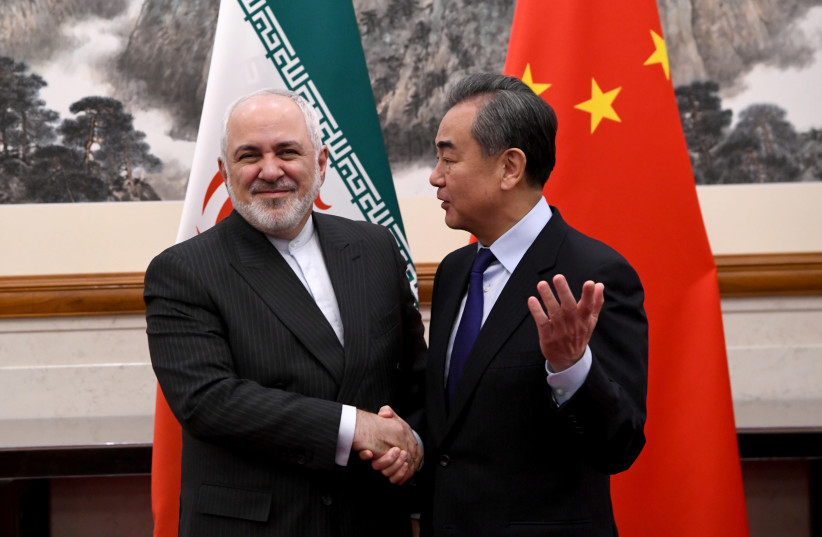 China's Foreign Minister Wang Yi shakes hands with Iran's Foreign Minister Mohammad Javad Zarif during a meeting at the Diaoyutai state guest house in Beijing, China December 31, 2019. (photo credit: REUTERS)