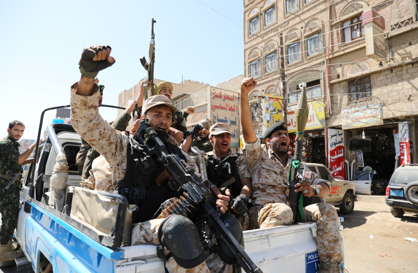Houthi troops ride on the back of a police patrol truck after participating in a Houthi gathering in Sanaa, Yemen (photo credit: KHALED ABDULLAH/ REUTERS)