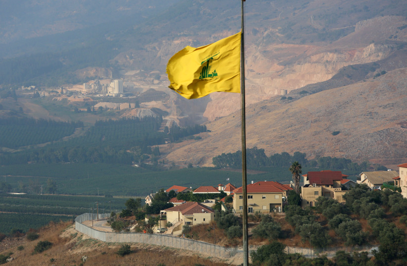 A Hezbollah flag flutters in the southern Lebanese village of Khiam, near the border with Israel, Lebanon July 28, 2020 (photo credit: REUTERS/AZIZ TAHER)