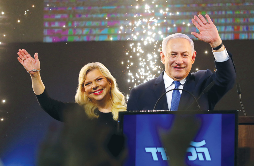 PRIME MINISTER Benjamin Netanyahu stands next to his wife, Sara, after speaking to supporters at his Likud party headquarters in Tel Aviv on March 3. (photo credit: AMIR COHEN/REUTERS)