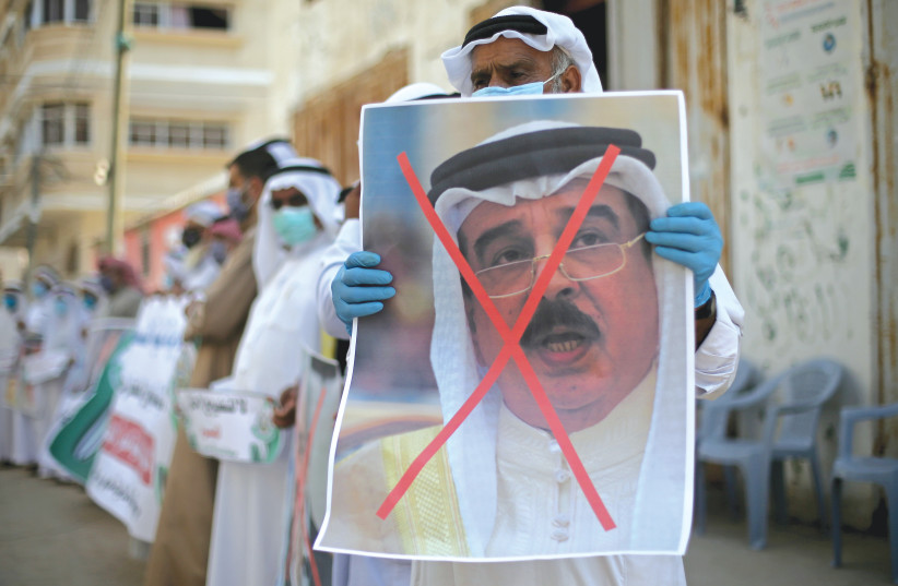 A MAN holds a poster depicting Bahraini King Hamad bin Isa Al Khalifa during a protest against normalization of relations with Israel earlier this month in the Gaza Strip.  (photo credit: IBRAHEEM ABU MUSTAFA / REUTERS)