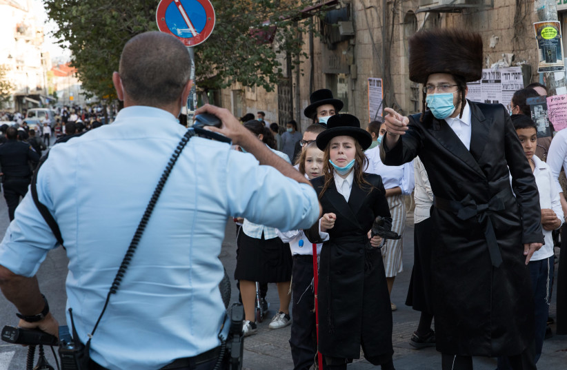 Israeli police officers clash with Ultra Orthodox Jewish men during a protest against the enforcement of coronavirus emergency regulations, in the Ultra Orthodox jewish neighborhood of Mea Shearim, Jerusalem, October 4, 2020 (photo credit: NATI SHOHAT/FLASH90)