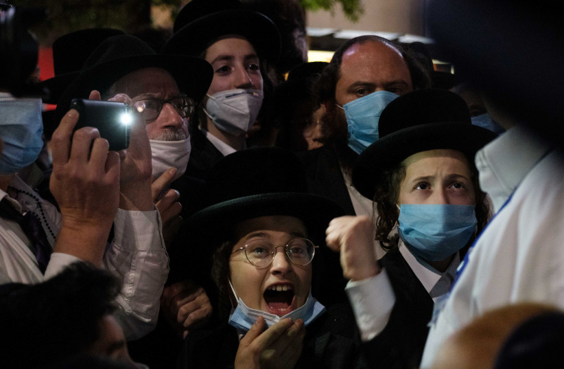 Ultra-Orthodox Jews gather in the Borough Park neighborhood of Brooklyn to protest against coronavirus disease (COVID-19) restrictions in New York, US, October 7, 2020.  (photo credit: REUTERS/YUKI IWAMURA)